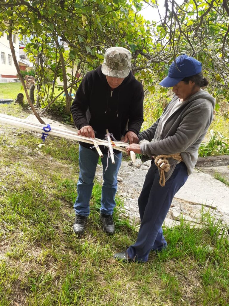 Mujer artesana de la asociación Manos Andinas tejiendo a cintura con técnicas tradicionales