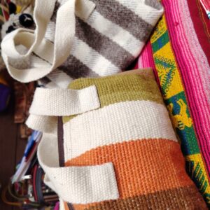 Bolso artesanal con asas de mano y patrones textiles tradicionales.