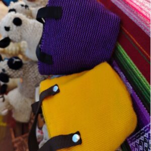 Monedero con forma de bolsa pequeña, tejido con hilos de colores y cierre de cordón.