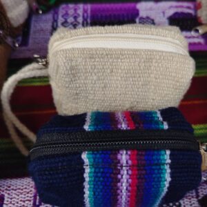 Monedero tejido con franjas azules y blancas, diseño tradicional andino.